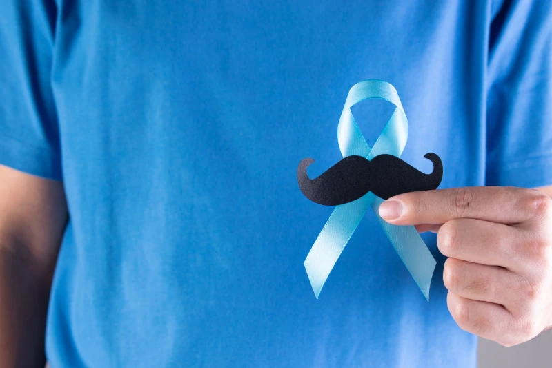 uomo sostenendo nastro azzurro con baffi - movember salute maschile